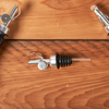 Wine bottle with corkscrew and pourer on wooden surface