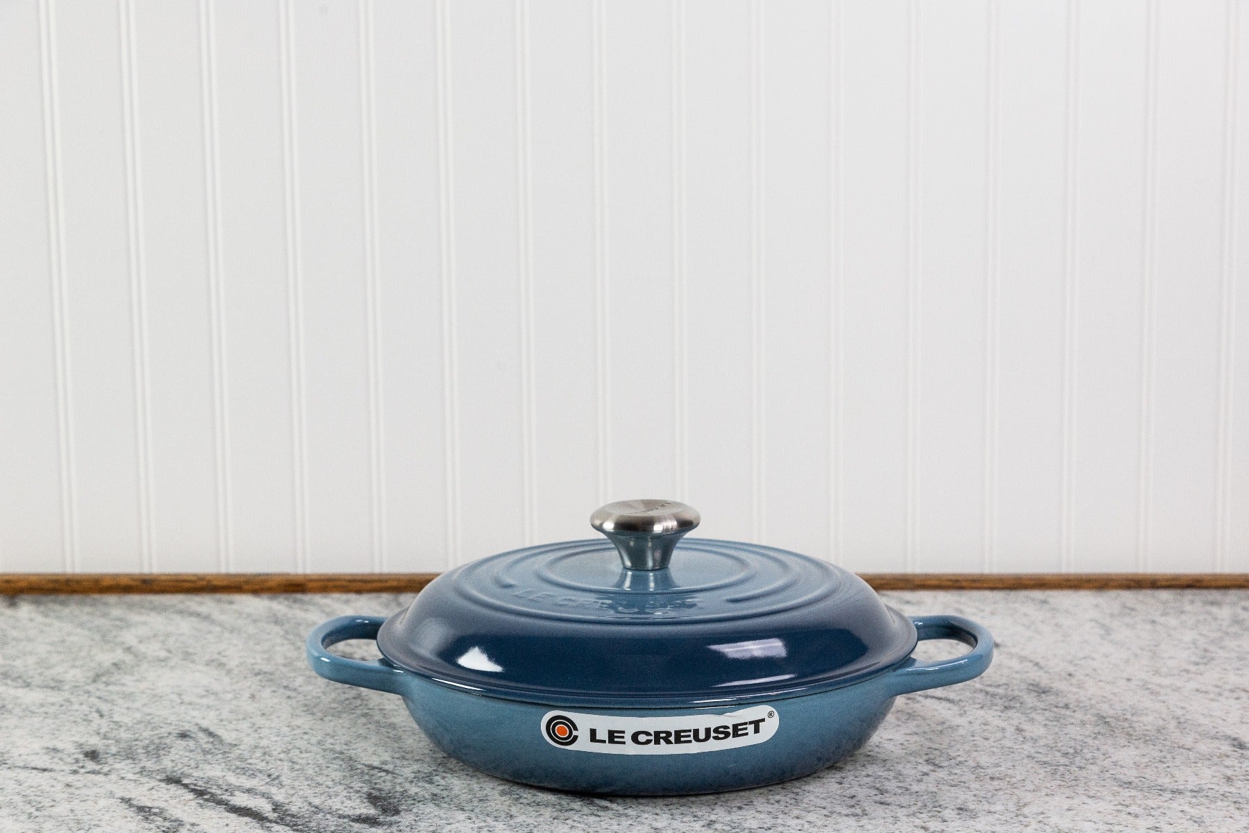 Blue Le Creuset cast iron casserole dish on kitchen counter