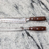 Stainless steel carving knife and fork set on marble background