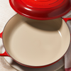 Le Creuset orange braiser with lid on a wooden surface