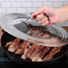 An RSVP Universal Glass Lid 7”-12” is used to cover a cast iron skillet full of bacon.