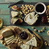 Gourmet cheese platter with figs, nuts, honey, and wine on a wooden table
