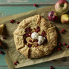 Rustic apple cranberry pie with scoop of vanilla ice cream, fresh fruits on wooden surface